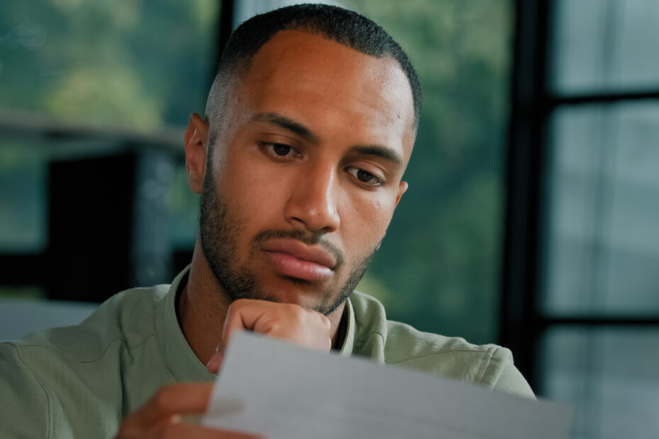 Man holding a paper, wondering about how visa or citizenship status affects his workers compensation rights