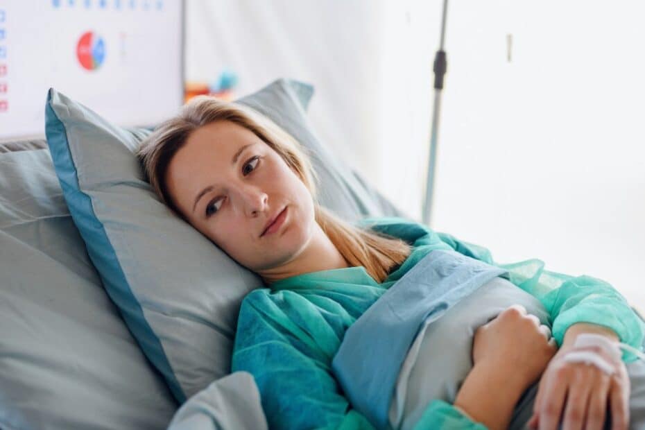 Woman lying in bed after experiencing birth trauma and medical negligence.